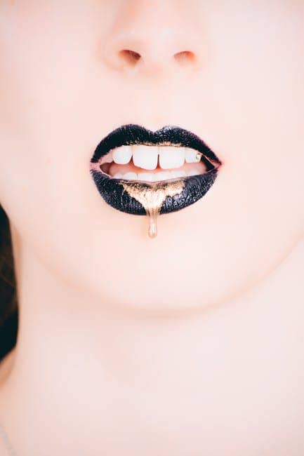 Mujer Vistiendo Lapiz Labial Negro Con Oro Goteando - Tipo de labios y como maquillarlos