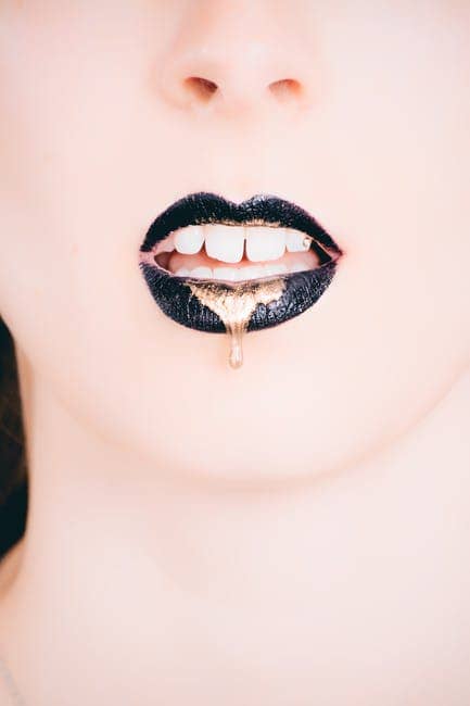 Tipo de labios y como maquillarlos Mujer Vistiendo Lapiz Labial Negro Con Oro Goteando - Tipo de labios y como maquillarlos